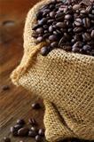 linen bag with coffee beans on wooden table