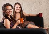 Two Grinning Ladies Sitting on Sofa