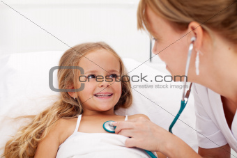  Little girl in bed having a health check