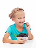 Happy girl eating fresh blackberry