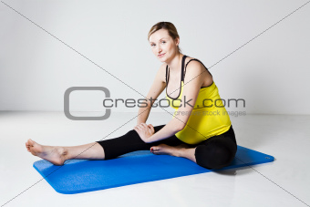 Pregnant woman performing leg stretch