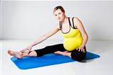 Pregnant woman performing leg stretch