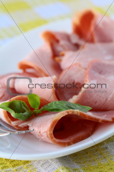 Baked sliced ham served on a white plate