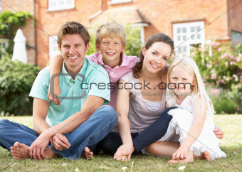 Family Sitting In Garden Together