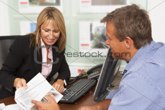 Female Estate Discussing Property Details With Client