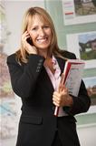 Portrait Of Female Estate Agent In Office On Phone