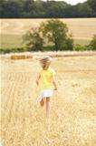Girl Running Through Summer Harvested Field