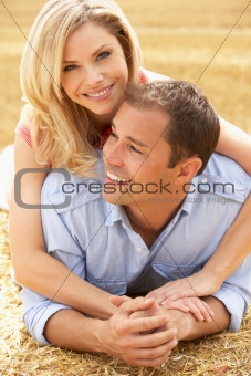 Couple Relaxing In Summer Harvested Field