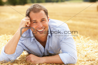 Portrait Of Man Laying In Summer Harvested Field