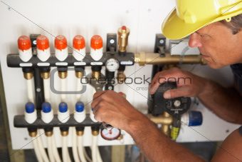 Plumber Working On Pipework In New Home