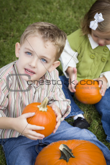 Cute Young Brother and Sister Children Enjoying the Pumpkins at the Pumpkin Patch.