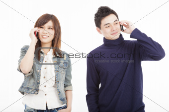 Young couple talking on mobile phone isolated on white