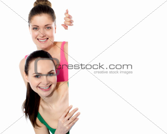 Two attractive girls holding blank whiteboard