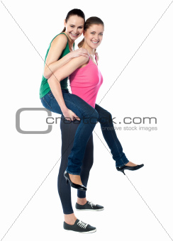 Teenage girl piggybacks her friend