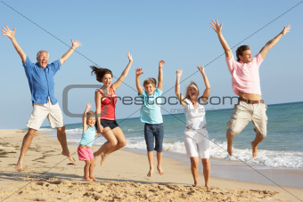 Portrait Of Three Generation Family On Beach Holiday Jumping In Air