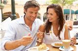 Young Couple Enjoying Coffee And Cake In Caf