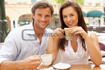 Young Couple Enjoying Coffee And Cake In Caf