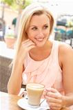 Young Woman Enjoying Cup Of Coffee In Caf