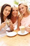 Three Women Enjoying Cup Of Coffee In Caf