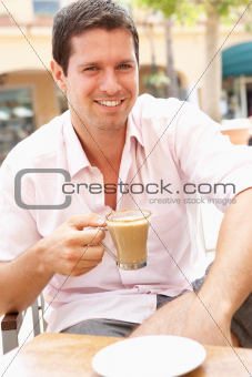 Young Man Enjoying Cup Of Coffee In Caf
