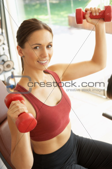 Young Woman Working With Weights In Gym