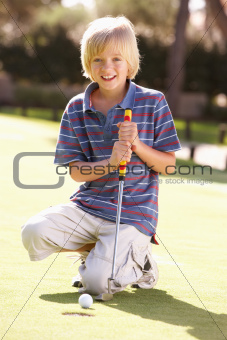 Young Boy Practising Golf On Putting On Green
