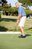 Senior Male Golfer On Golf Course Putting On Green