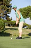 Female Golfer On Golf Course Putting On Green