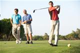 Group Of Male Golfers Teeing Off On Golf Course