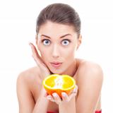 amazed woman holding an orange