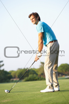 Male Golfer Teeing Off On Golf Course