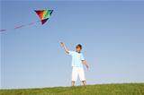 Young boy poses with kite in a field