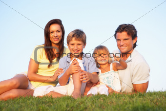 Young parents, with children, posing on a field
