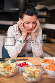 Depressed young woman in kitchen 