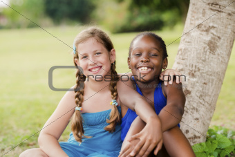 Two happy female friends hugging and looking at camera