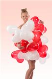 blonde girl with many balloons on her body, she touches those