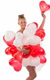 blonde girl with many balloons on her body takes one balloon