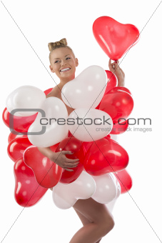 blonde girl with many balloons on her body. she smiles