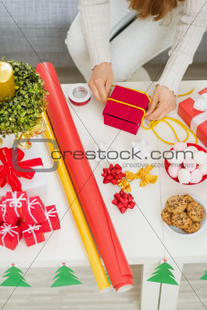 Closeup on female hand preparing Christmas gift