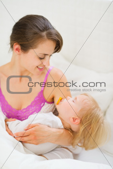 Smiling young mother holding sleeping baby