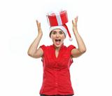 Smiling woman in Santa hat with Christmas present box on head