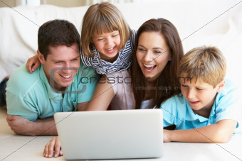 Young parents, with children, on laptop computer