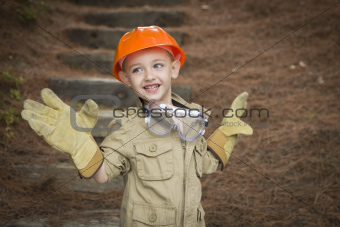 Happy Adorable Child Boy with Big Gloves, Hard Hat and Goggles Playing Handyman Outside.