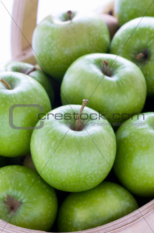 green granny smith apples in a wooden trug