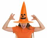 Woman in Halloween hat over eyes making scaring pose