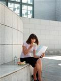 business person eating lunch outside office and reading papers