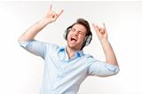 excited man in blue shirt with earphones listening to music 