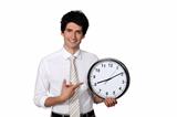 Happy businessman showing a clock