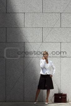 attractive woman speaking on telephone near office building