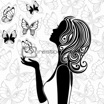 Silhouette of young woman with flying butterflies